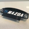 Blue M White Mazda black plate 12a cover